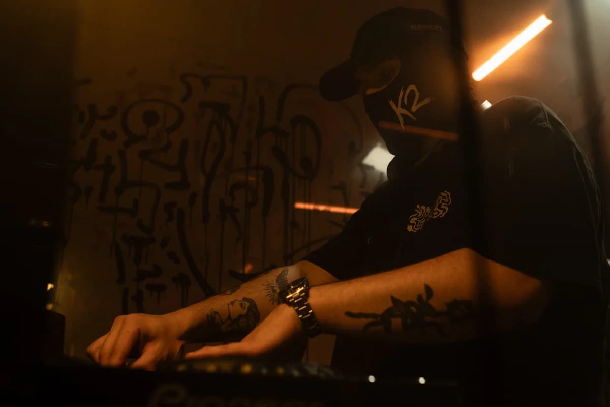 Masked DJ performing under warm nightclub lights