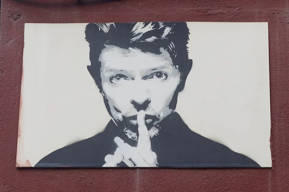 Black-and-white mural portrait of David Bowie on a wall.