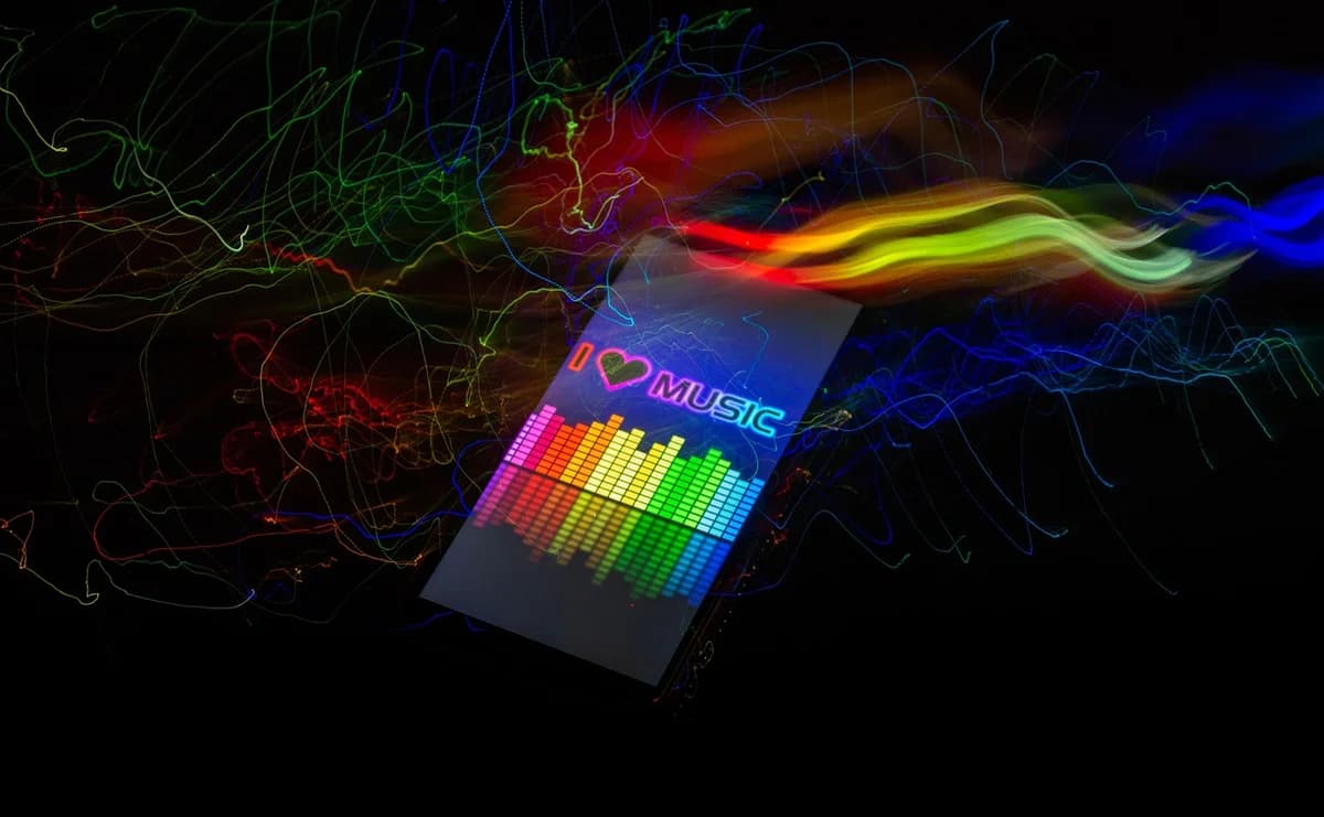 Abstract neon light painting with rainbow streaks and a music equalizer graphic