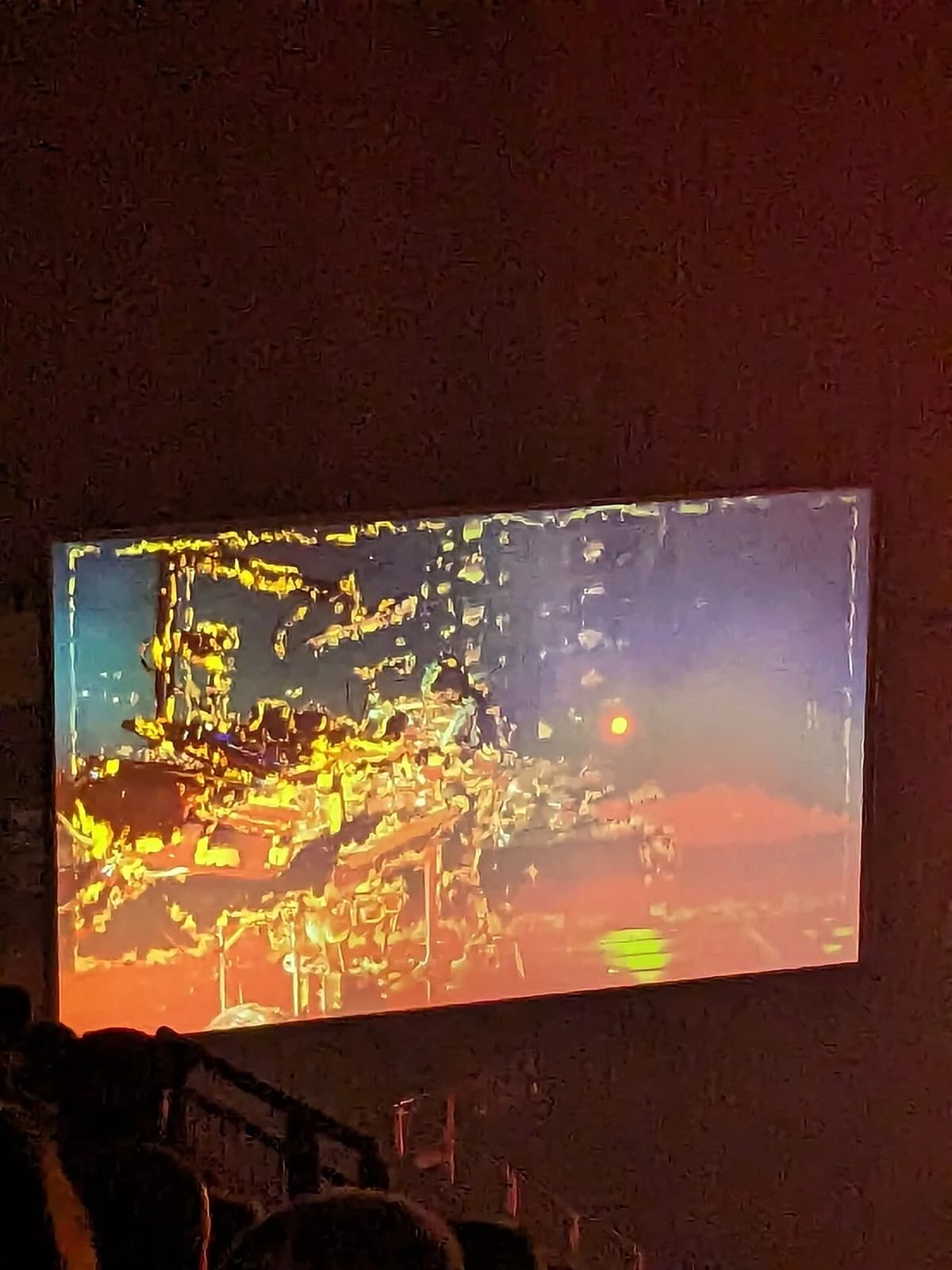 A live concert performance by Muse shown on a large screen in an arena.