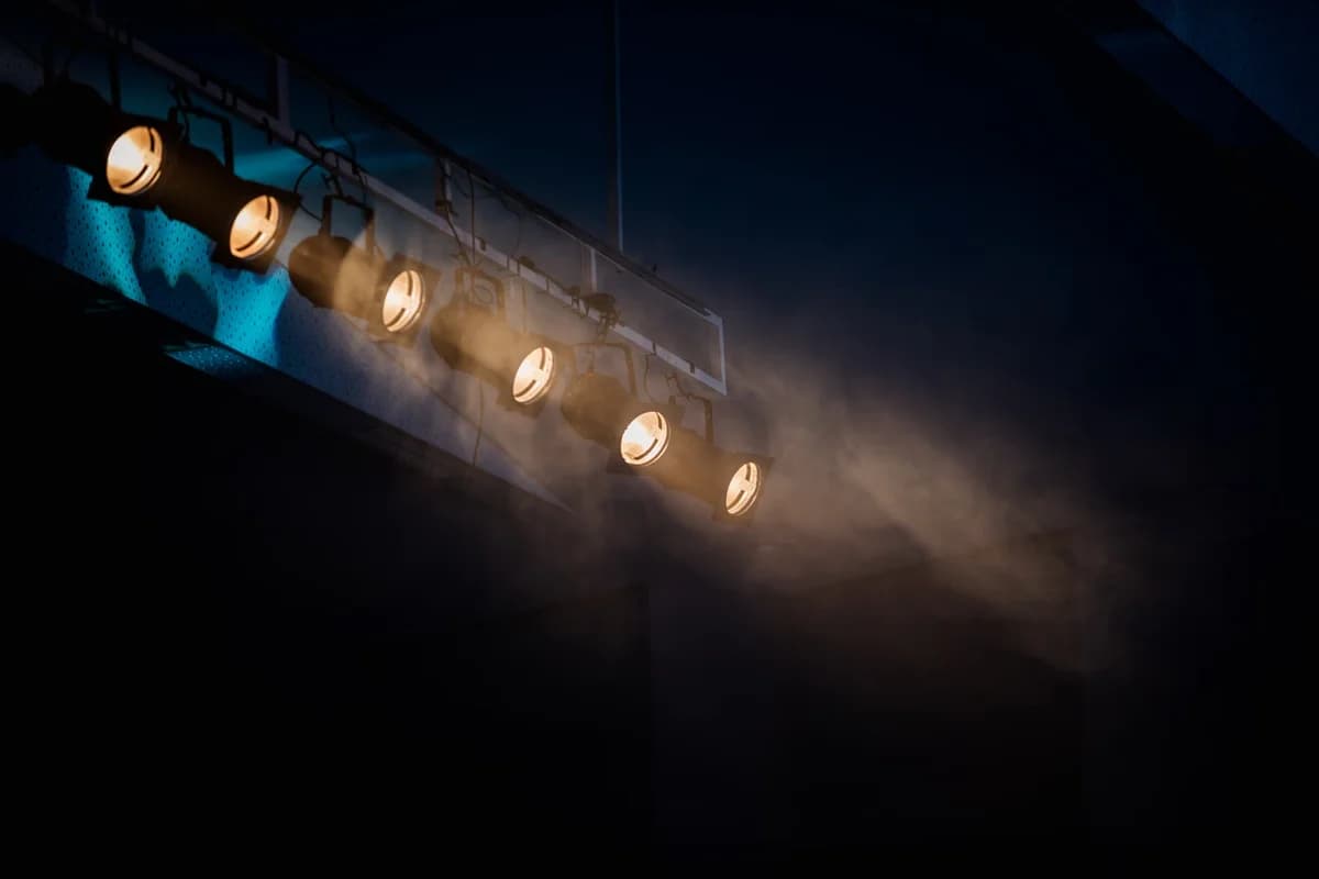 Stage lights shining through smoke creating a dramatic effect