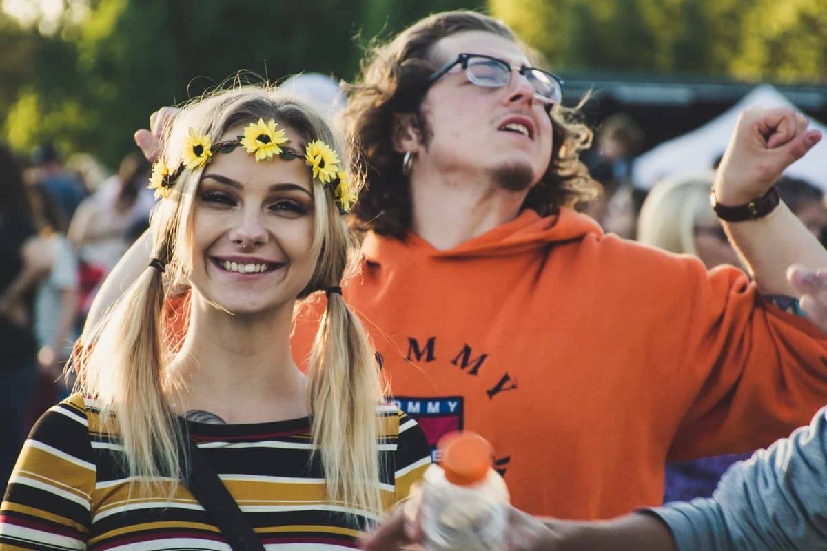 A young woman with flower crown smiling at an outdoor festival.