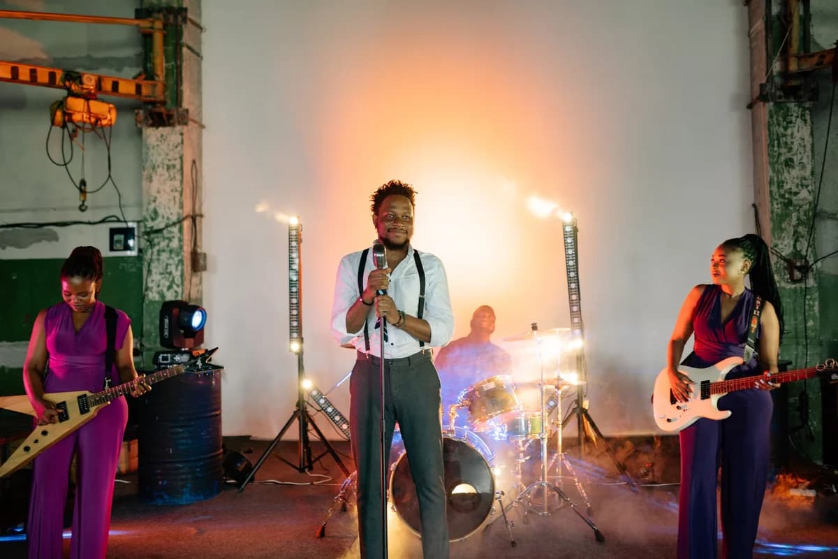 A band performing indoors under dramatic stage lights and smoke.