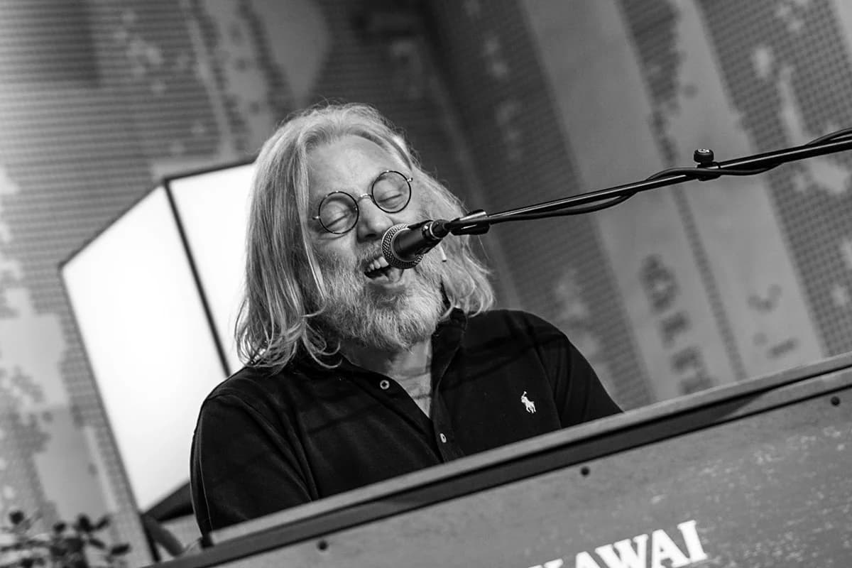Black-and-white photo of Søren Huss singing at a keyboard during a festival performance.