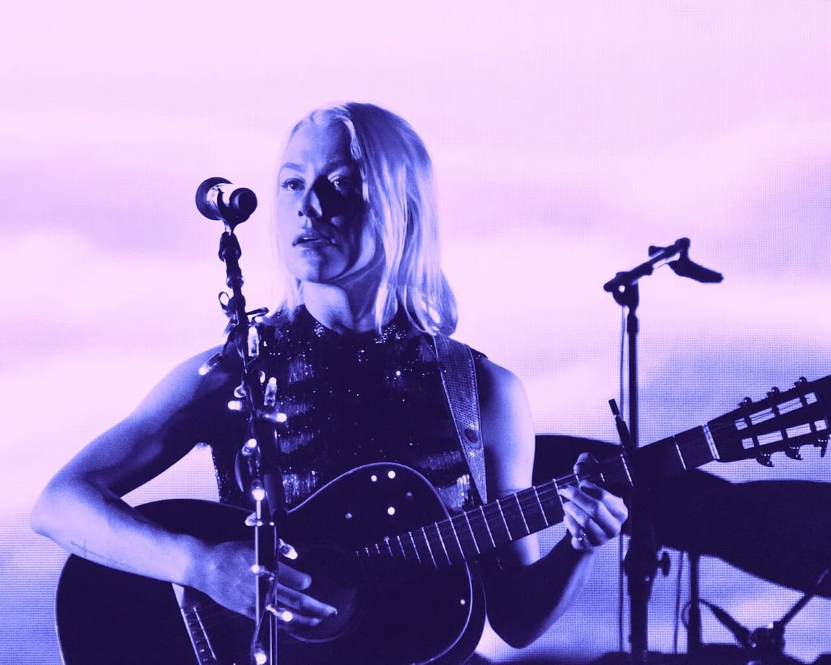 Blonde female musician playing guitar on stage