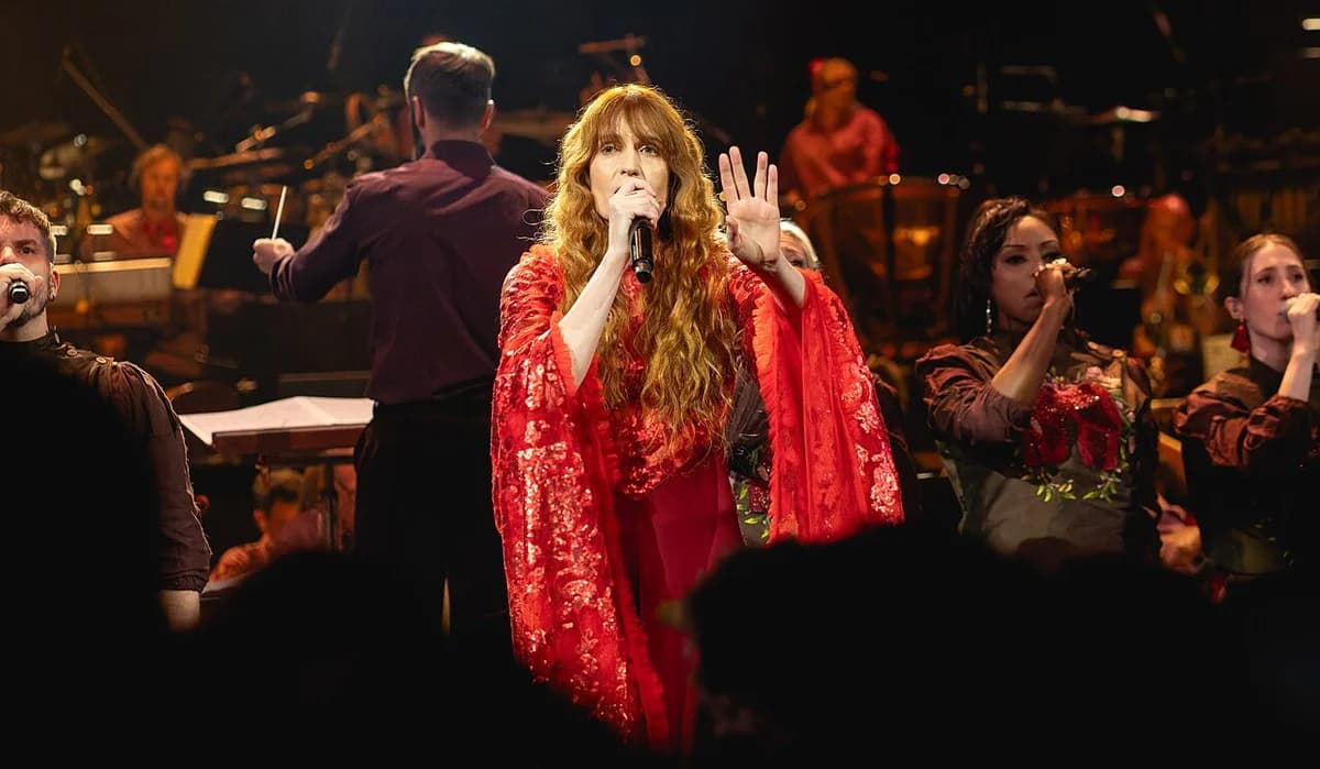 Florence Welch sings on stage with an orchestra at BBC Proms in Royal Albert Hall.