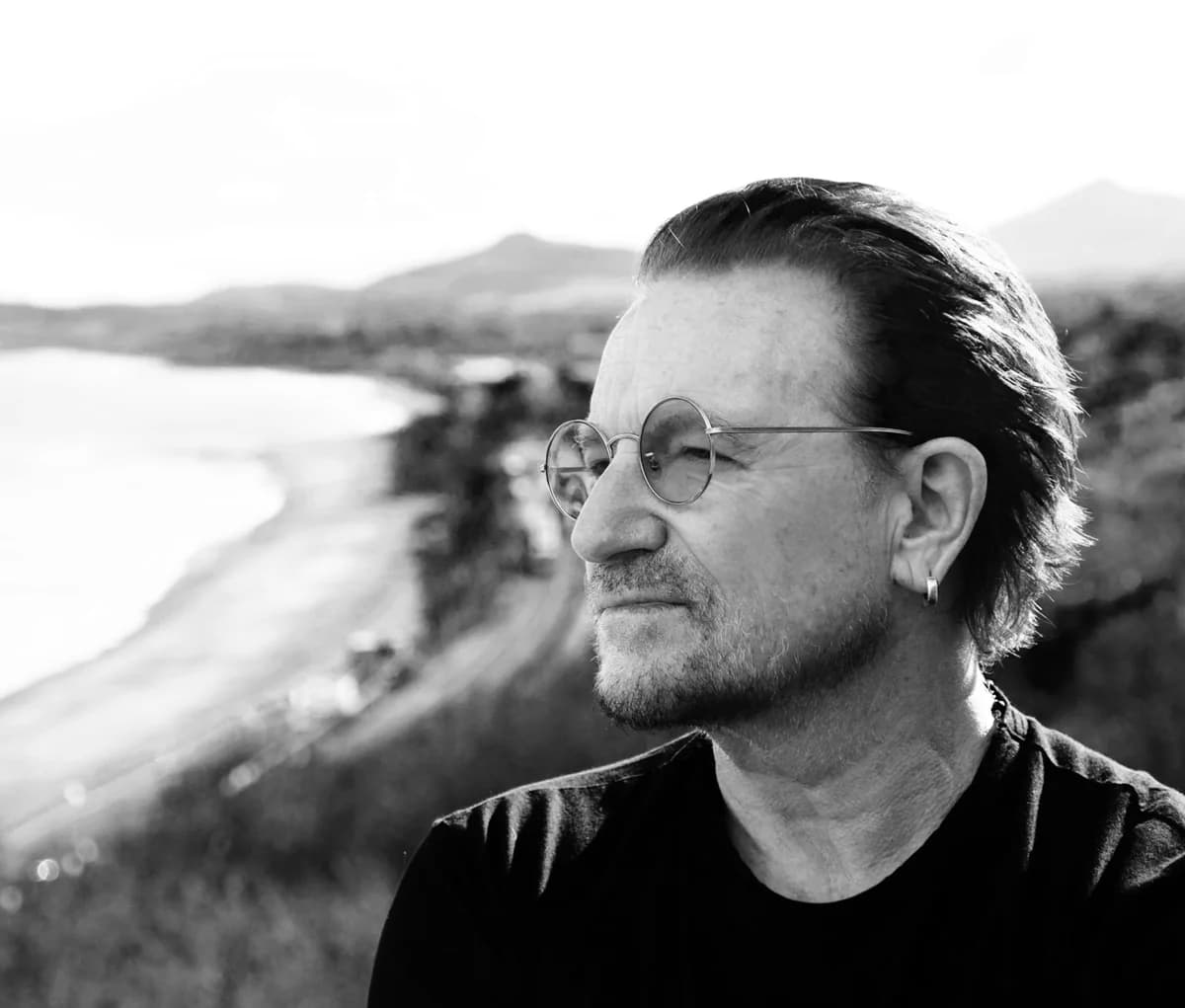 Black-and-white portrait of Bono by the sea.