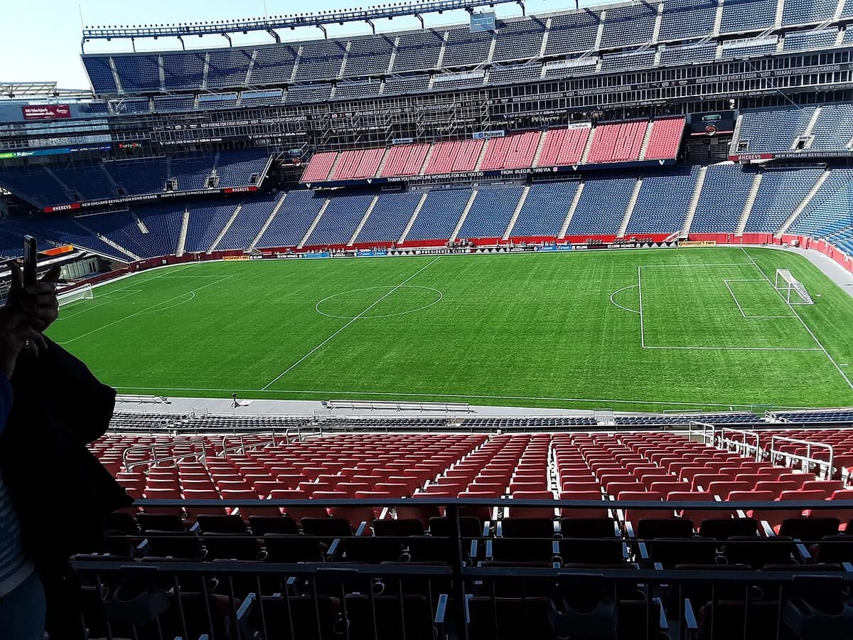 Interior view of Gillette Stadium with empty seats and a green field.