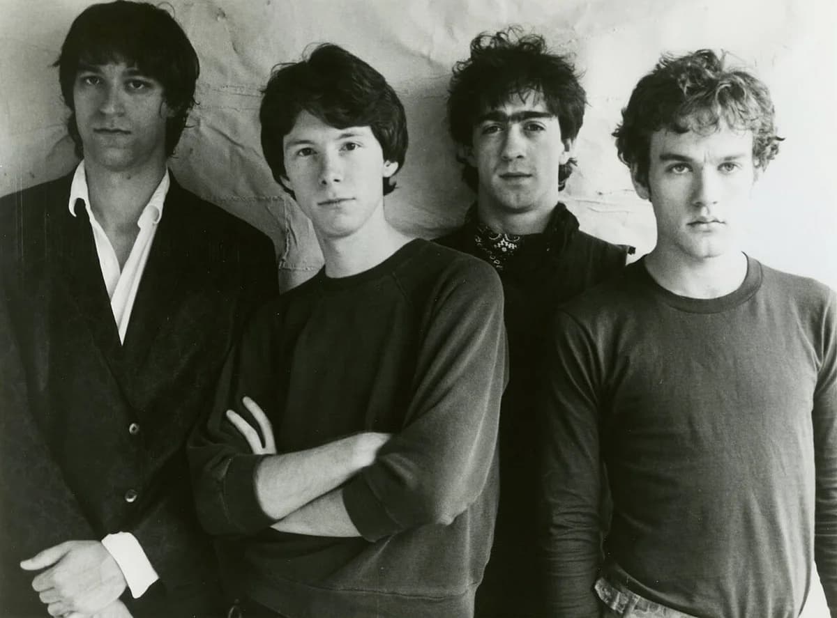 Black-and-white photo of four members of R.E.M. posing together.