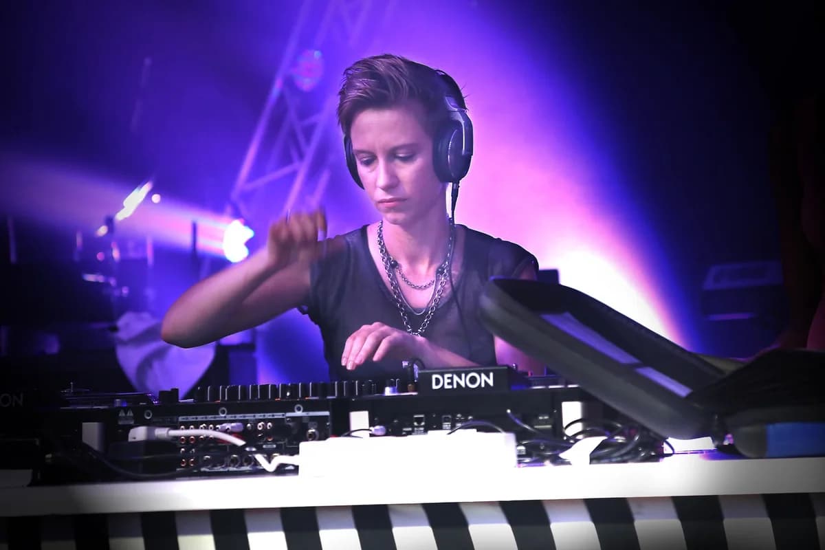 Female DJ performing under purple nightclub lights