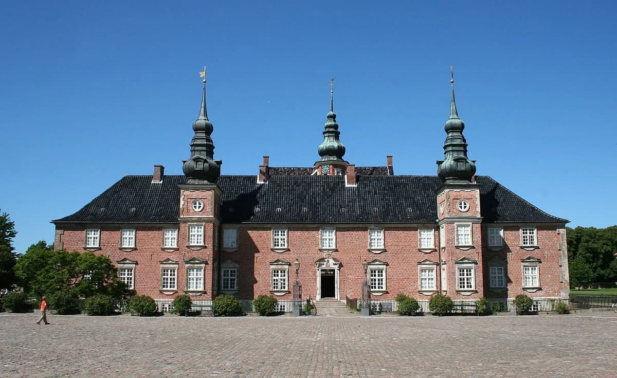 Jægerspris Castle photographed in daylight under a blue sky.