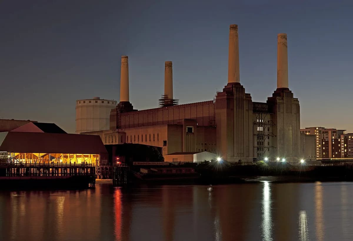 Battersea Power Station at dusk beside the River Thames in London.