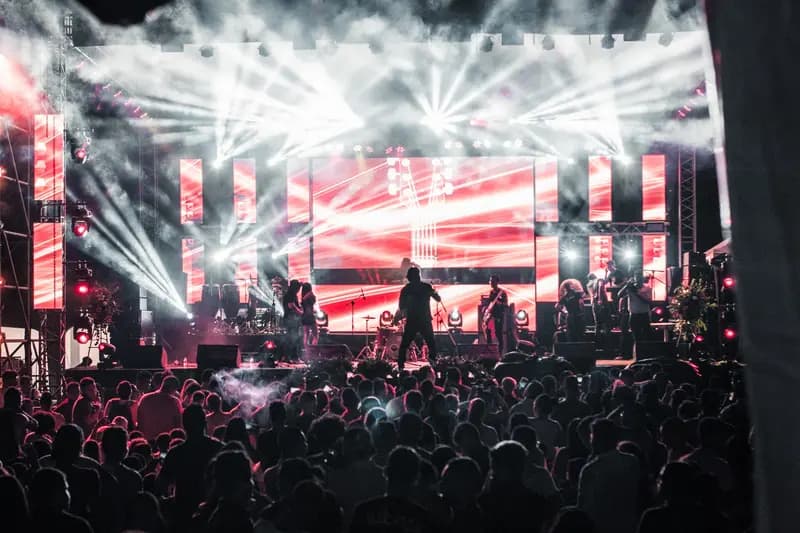 Performers on a brightly lit stage with a crowd watching