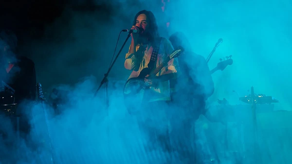 A band performing on a foggy, blue-lit stage.