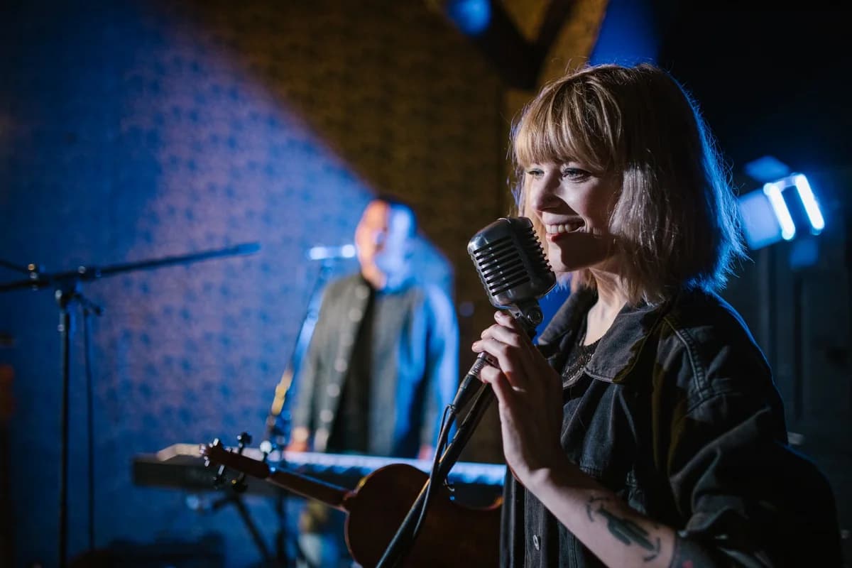 Smiling woman singing into vintage microphone on stage