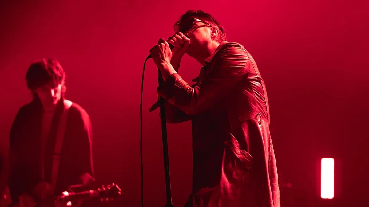 A band performing live on a red-lit stage.