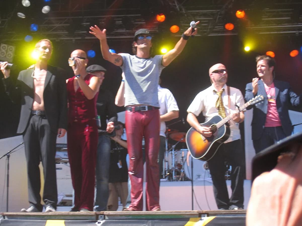 Band performing live on stage with bright lights
