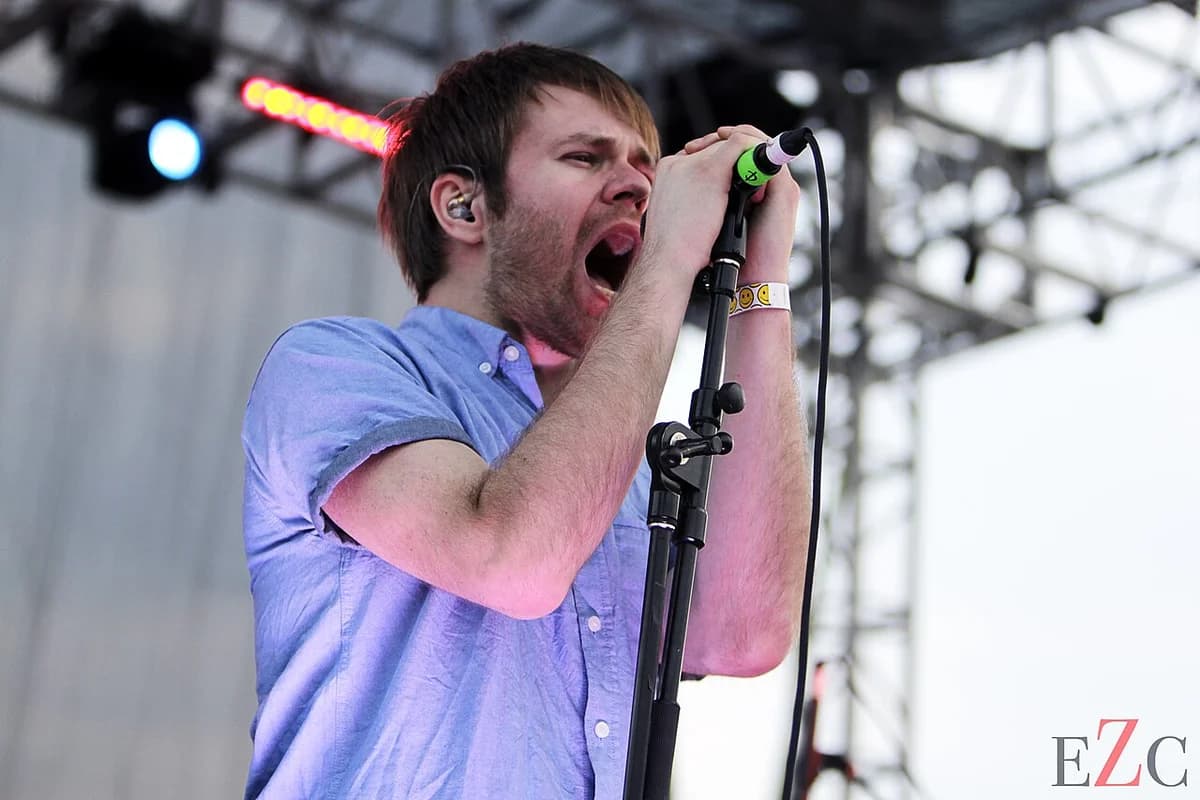 Rou Reynolds singing on stage into a microphone during a live performance.
