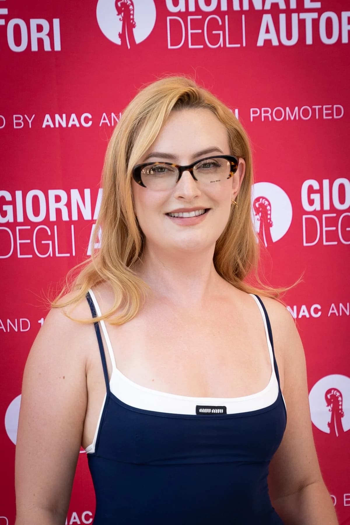 Amelia Dimoldenberg posing on a Venice Film Festival red carpet.