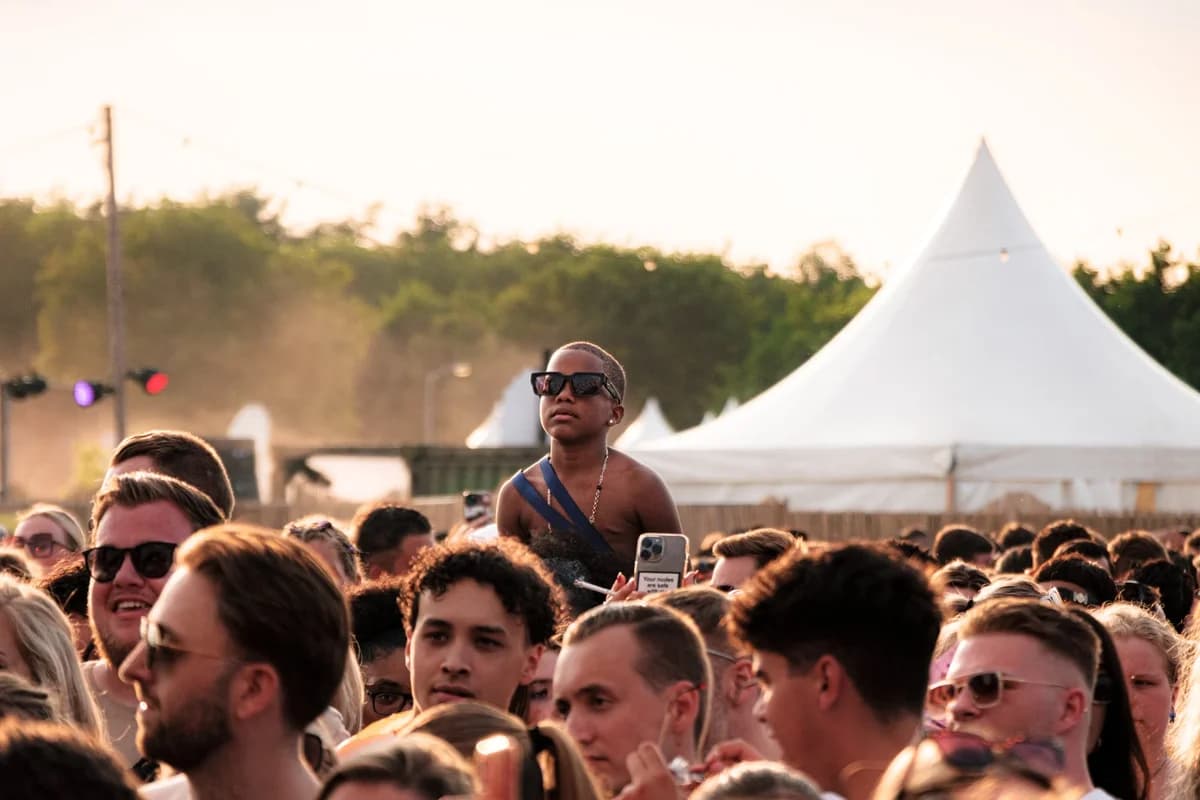 crowd at outdoor music festival with white tent