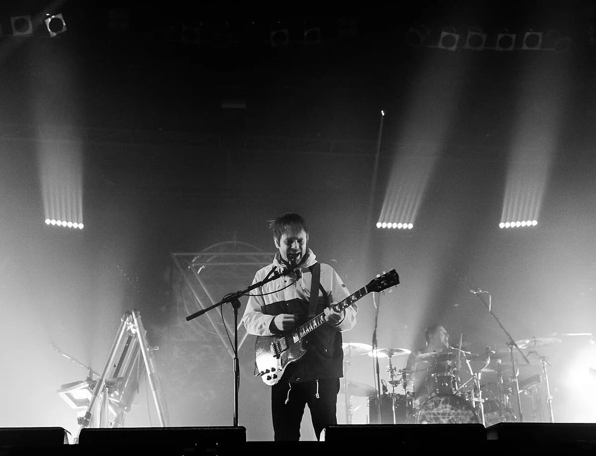 Black-and-white photo of Enter Shikari performing on stage at a festival.