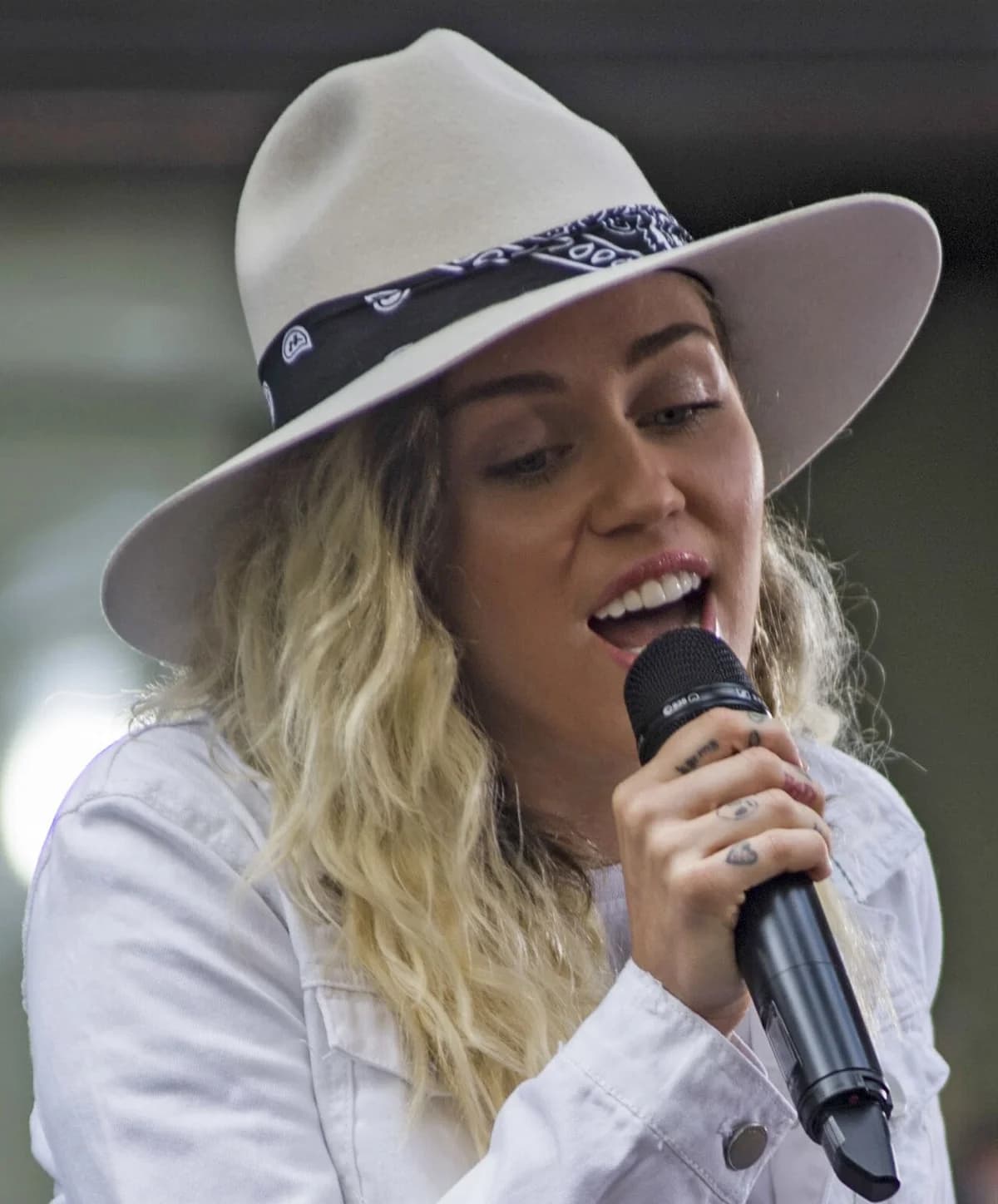 Miley Cyrus singing into a microphone during a live performance.