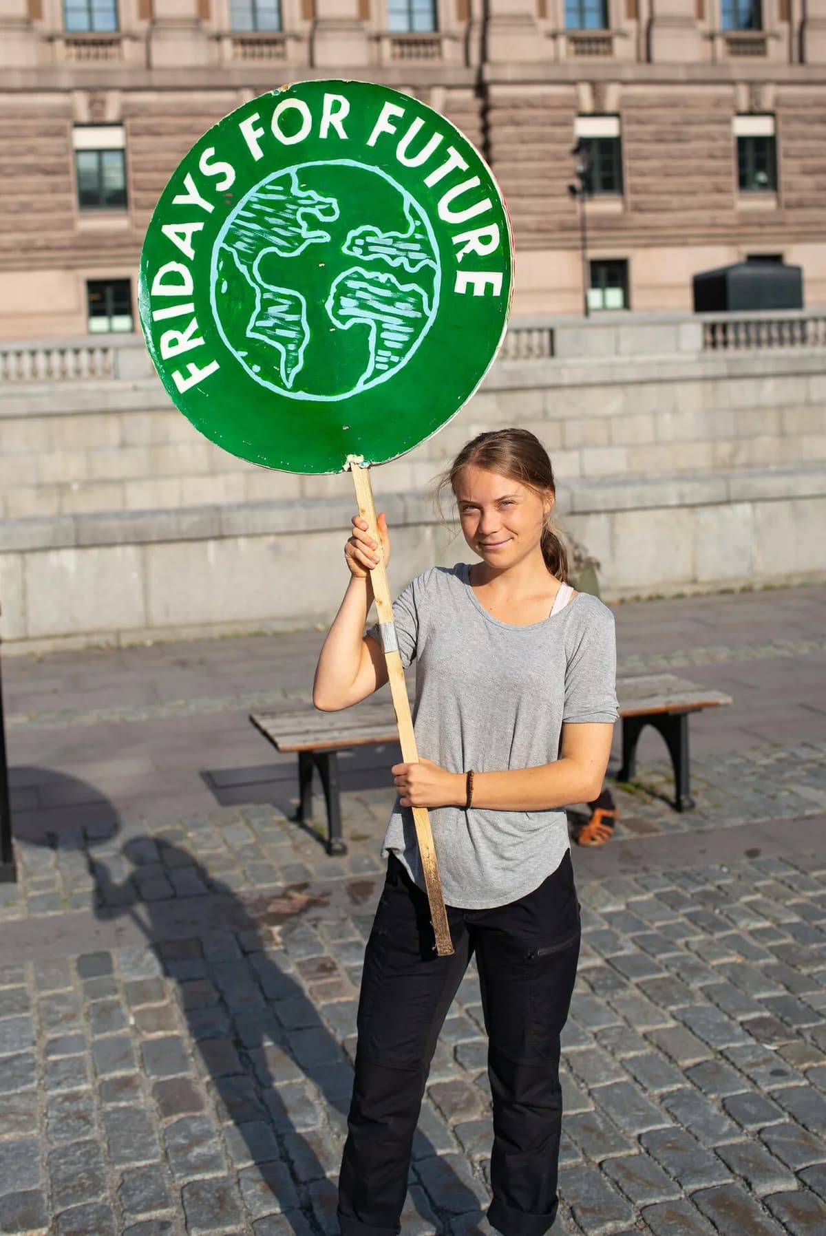 Greta Thunberg holding a Fridays for Future protest sign in Stockholm.