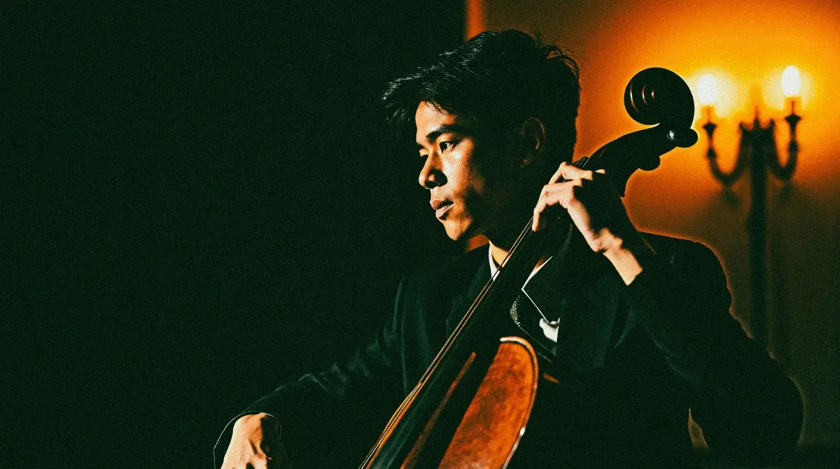 A cellist playing in dramatic warm light.