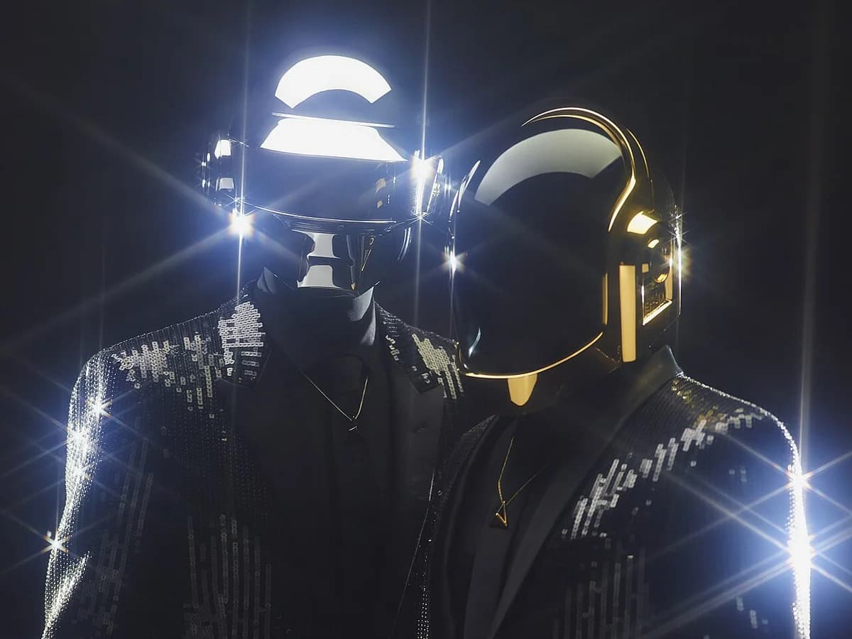 Daft Punk duo wearing helmets and sparkling jackets