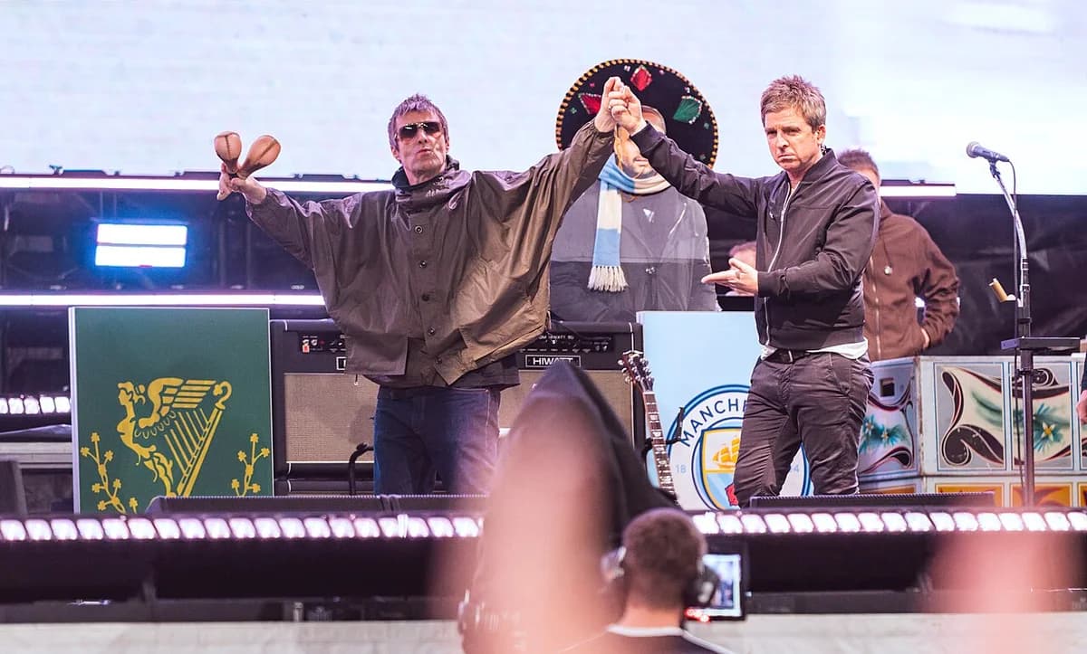 Oasis performing on stage at Wembley Stadium in London.