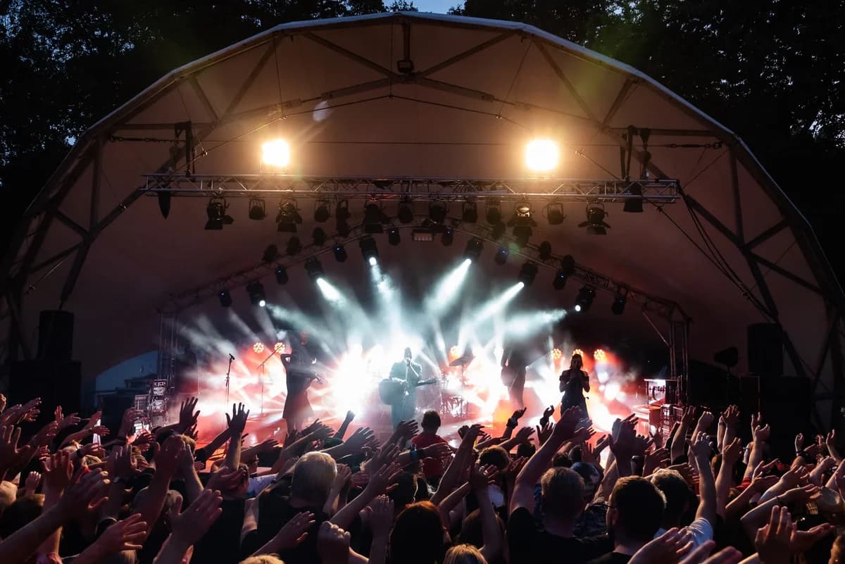 Crowd watching a live band perform on an outdoor stage at night