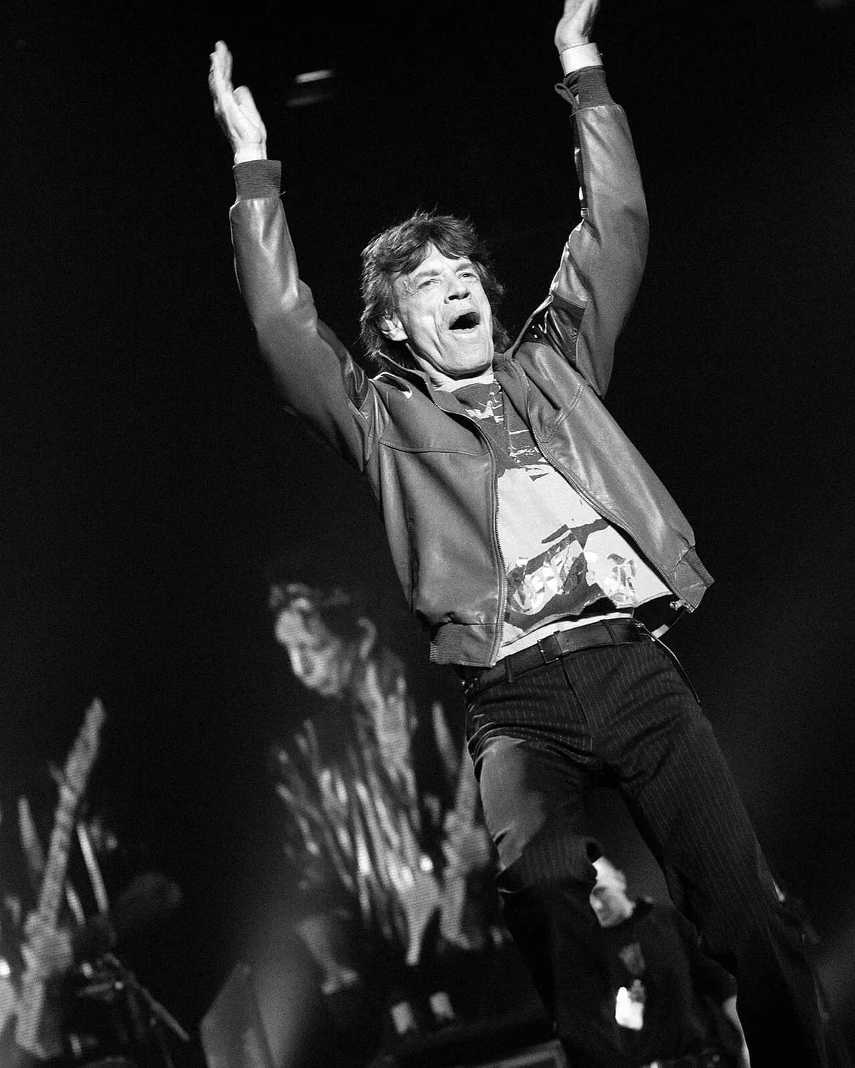 Mick Jagger on stage with raised arms
