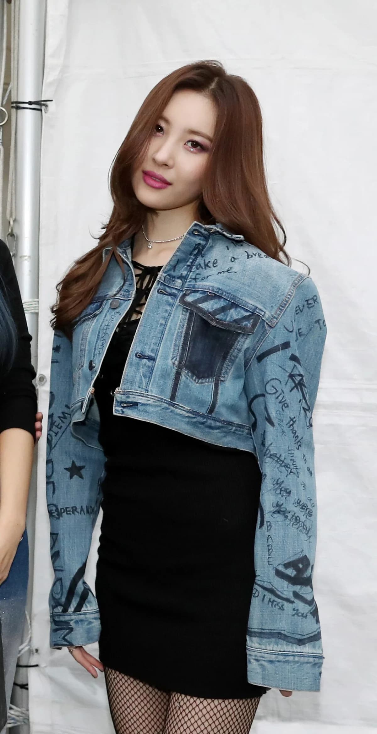 Lee Sunmi posing in a black dress and denim jacket at an event.