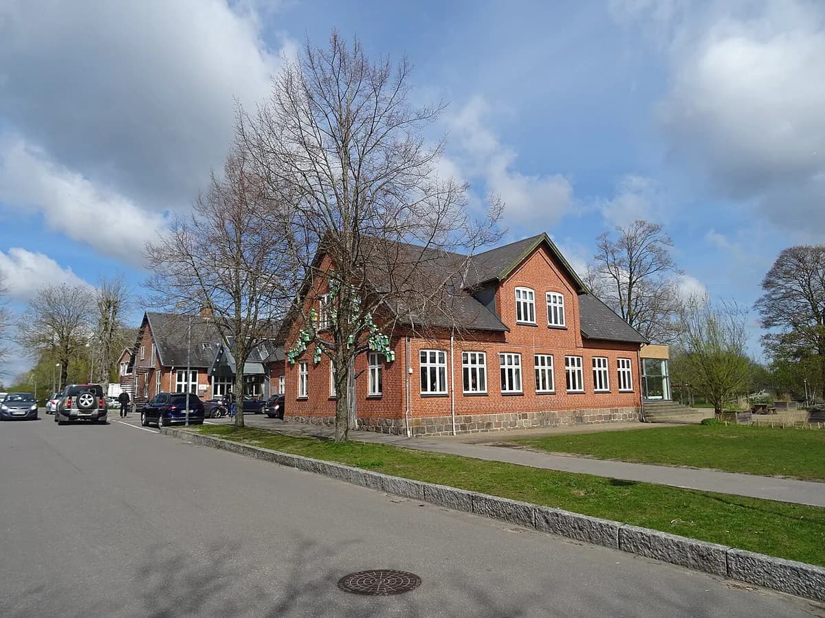 A red brick cultural center building beside a road in a Danish town.