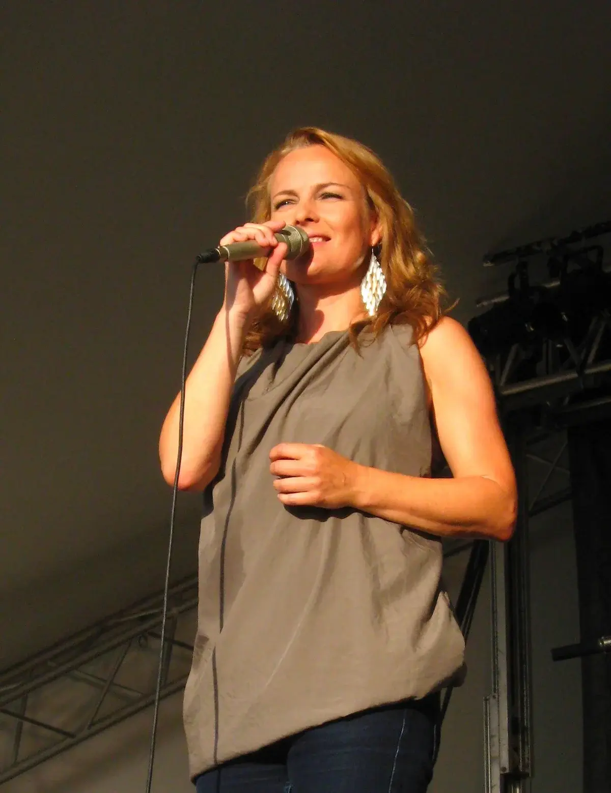 Søs Fenger singing on stage at a live performance.
