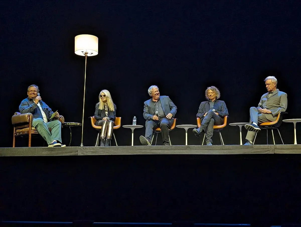 Talking Heads members seated on stage during a Q&A event.